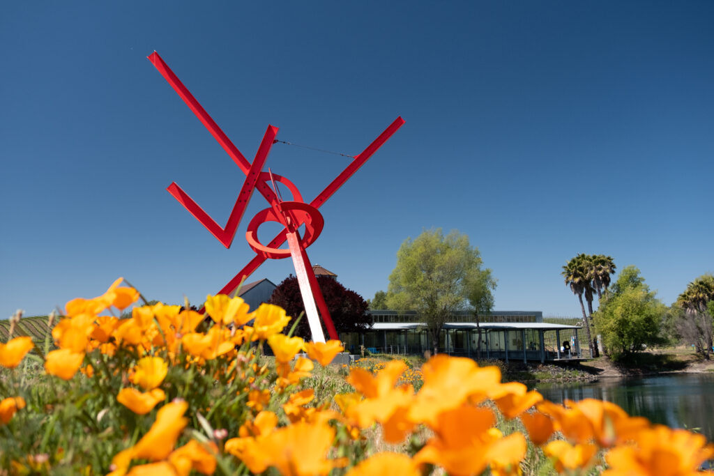 A red sculpture and poppies